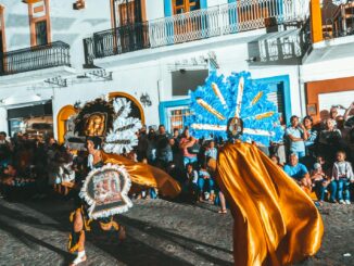 Vibrant street parade with colorful costumes and dancers in Puerto Vallarta, Mexico.